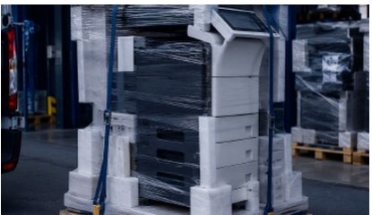 Folienverpacktes Multifunktionssystem auf einer Palette, mit Spanngurten gesichert.